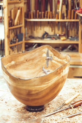 A handcrafted wooden bowl, inlaid with peregrine falcons made from recycled silver